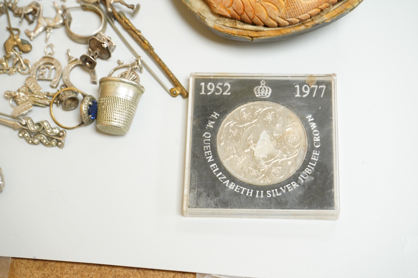 A small collection of silver and white metal charms, including Holy Bible, Penny Farthing, hedgehog and squirrel, together with a silver compact and ashtray, a silver and paste brooch, nut vesta, pipe, etc.
